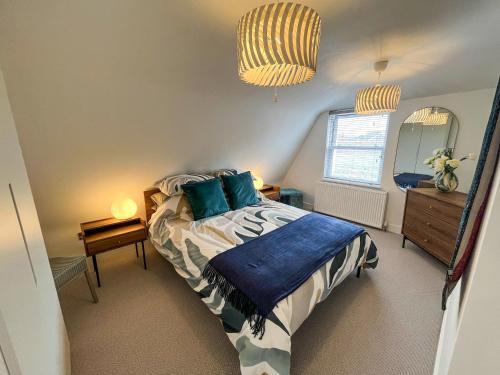 a bedroom with a bed and a dresser and a window at Whitstable May House in Whitstable