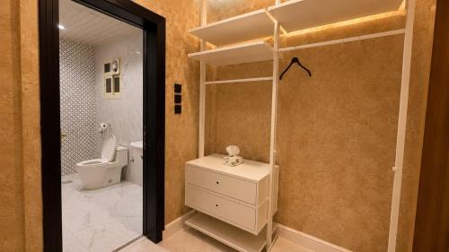 a bathroom with a toilet and a sink and a mirror at شقق رواق in Abha