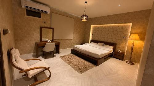 a bedroom with a bed and a desk and a chair at شقق رواق in Abha