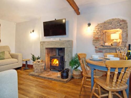 a living room with a table and a fireplace at Quarry Cottage in Barnoldswick