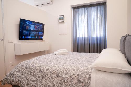 a bedroom with a bed and a flat screen tv at Hortus slow room in Montesarchio