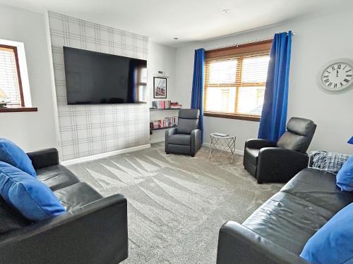 a living room with two couches and a flat screen tv at Broadsea Cottage in Fraserburgh