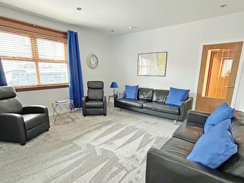 a living room with couches and blue pillows at Broadsea Cottage in Fraserburgh