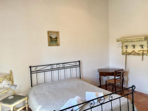 a bedroom with a bed and a chair and a table at Vitalenta Agriboutique in Pienza