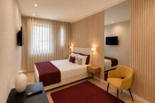 a hotel room with a bed and a chair at MyTrip Porto in Matosinhos