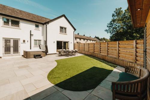 a garden with a wooden fence and a lawn at Upper Oak House in Windermere