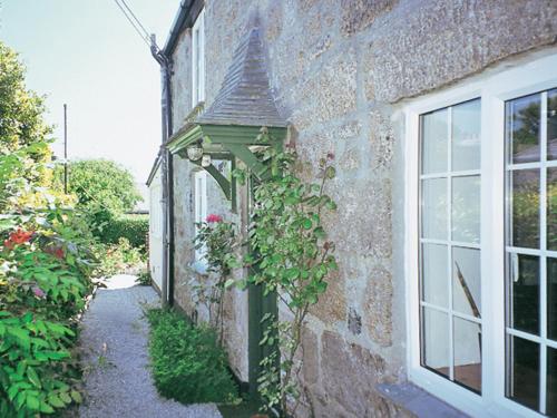a garden entrance to a brick building with a pergola at Chy-Vean in Madron
