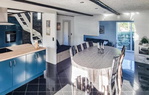 a kitchen and dining room with a table and blue cabinets at Stunning Home In Sæby in Sæby