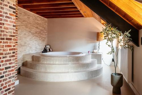 a circular staircase in a room with a brick wall at Vakantiewoning - Camping Groenpark in Berlare
