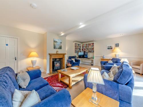 a living room with blue couches and a fireplace at Carriage House - Uk49288 in Preston