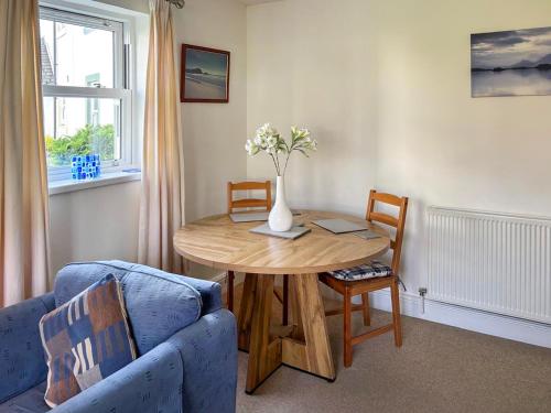 a living room with a table and a blue couch at 11 Elm Court in Keswick