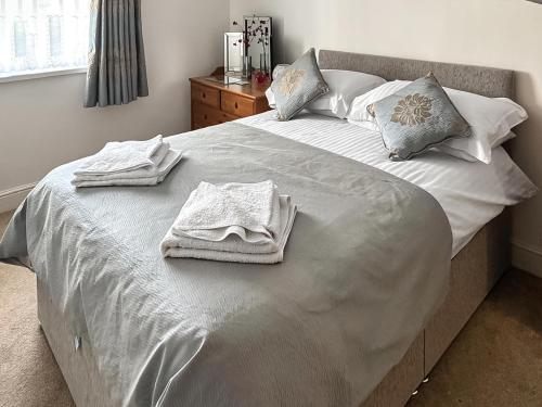 a bedroom with a bed with towels on it at 11 Elm Court in Keswick