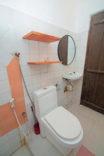a bathroom with a toilet and a sink and a mirror at Bahari Studio Apartment in Bwejuu