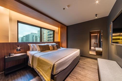 a bedroom with a large bed and a large window at Laghetto Stilo São Paulo in São Paulo