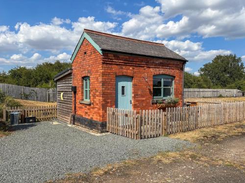 a small brick house with a wooden fence at The Weighbridge in North Clifton