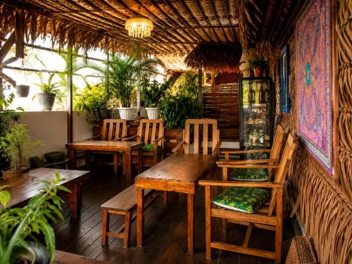 a restaurant with wooden tables and chairs and plants at Feliz Puerta - Entire House with Rooftop Terrace, Iquitos in Iquitos