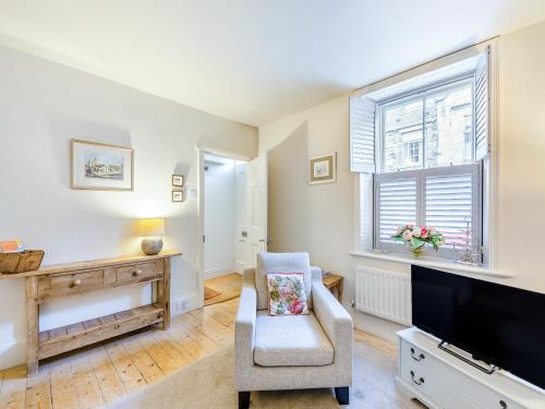 a living room with a tv and a chair at Chareside Cottage in Corbridge