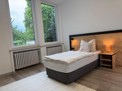 a bedroom with a bed and two windows at Blue Stay 2 in Bremen