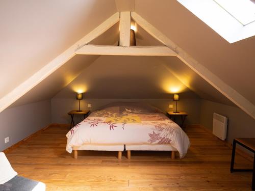 a bedroom with a bed in the attic at La Petite Maison De Rose in Flancourt-Crescy-en-Roumois