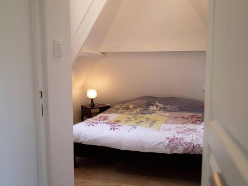 a bedroom with a bed and a lamp on a table at La Chaumière in Flancourt-Catelon