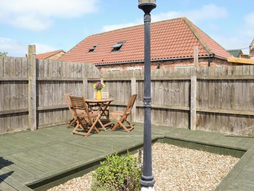 a patio with a table and chairs and a fence at Meadow View - Iom in Brandesburton