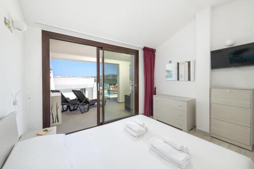 a bedroom with two beds and a view of a patio at NRH Cannigione Sunrise Rooftop in Cannigione