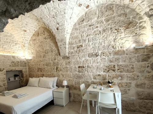 a bedroom with a bed and a table in a brick wall at La Carruba in Ceglie Messapica