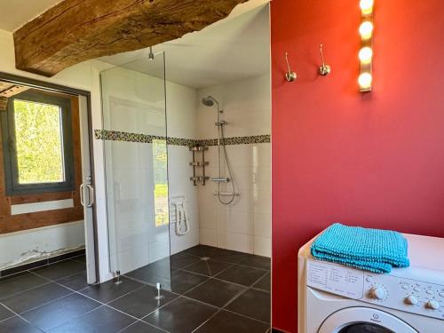 a bathroom with a shower and a washing machine at La longère in Flancourt-Catelon