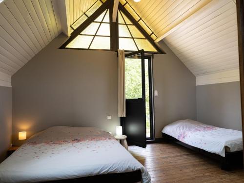 a bedroom with two beds and a large window at La longère in Flancourt-Catelon