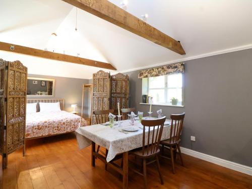 a bedroom with a table and chairs and a bed at The Old Dairy in Warminster