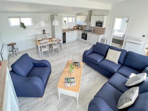a living room with two blue couches and a table at St Mabyn Lodge Escape in Bodmin