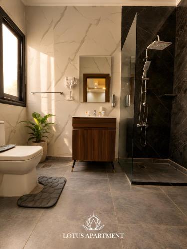 a bathroom with a shower and a toilet and a sink at Lotus Two Hotel l New Cairo in Cairo