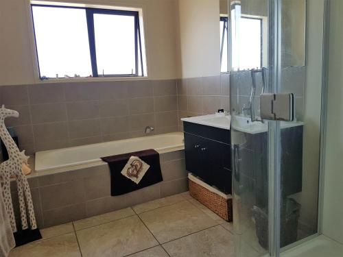 een badkamer met een bad, een wastafel en een douche bij Tokatoka views Farmstay in Ruawai