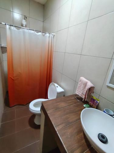 a bathroom with a toilet and a sink and a shower at Raices Boulevard Hotel in Portachuelo