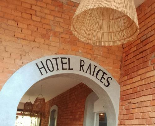 a sign that reads hotel rakes hanging from a brick wall at Raices Boulevard Hotel in Portachuelo