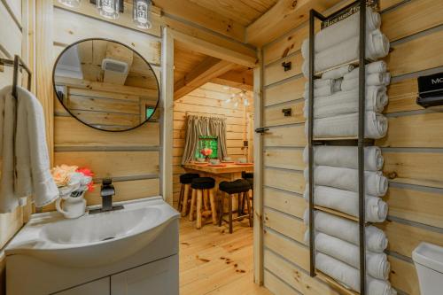 a bathroom with a sink and a vanity with a mirror at Peaceful Luxury in the Smokey Mountains w Hot Tub and Pet Friendly Cabin B in Elizabethton