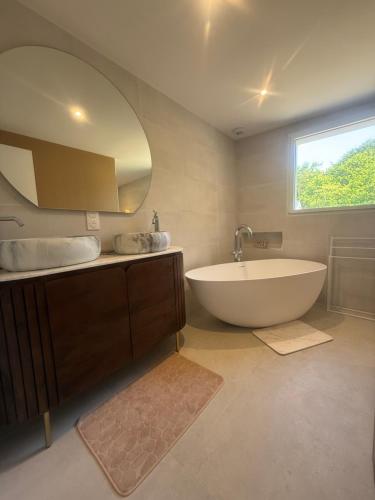 a bathroom with a tub and a sink and a mirror at L Œil de L Horizon in Lanildut