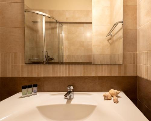 a bathroom with a sink and a mirror at Canvas by Mitsis Belvedere in Benitses