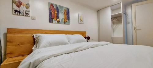 a bedroom with a white bed and some pictures on the wall at Barnhouse Cottage - Sauna & Steam bath - in Tigoni in Nairobi
