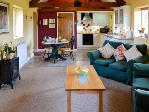 a living room with a couch and a table at Barleycorn in Holwell