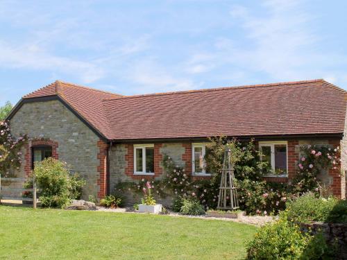a red brick house with a garden and a ladder at Barleycorn in Holwell