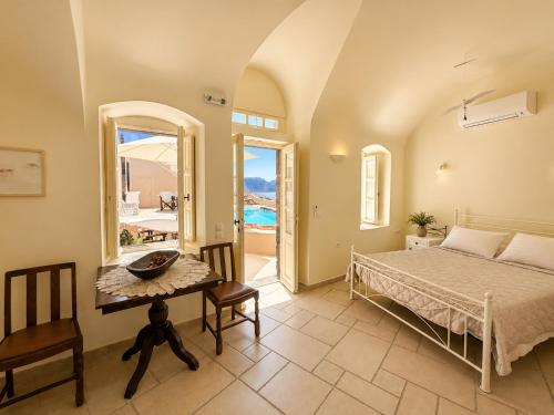 a bedroom with a bed and a table at Grand Canava in Oia