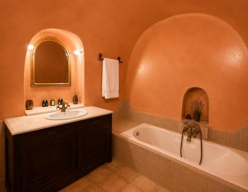 a bathroom with a sink and a bath tub at Grand Canava in Oia