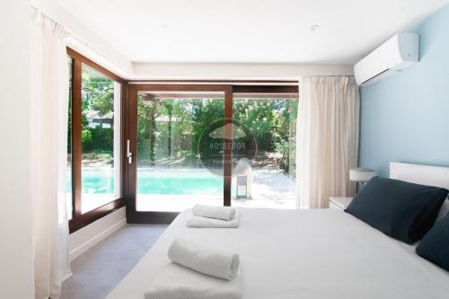a bedroom with a bed and a large window at Villa Igelak - Hossegor - Centre - Lac - Piscine in Soorts-Hossegor