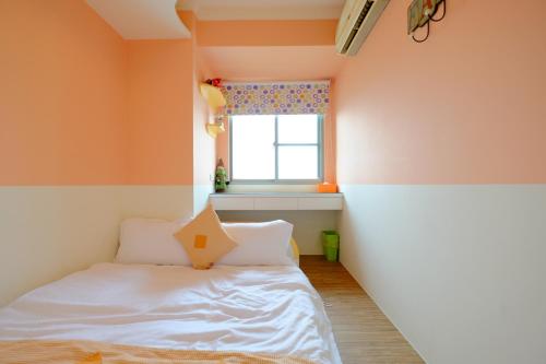 a small room with a bed and a window at CT Theme Suite in Kaohsiung