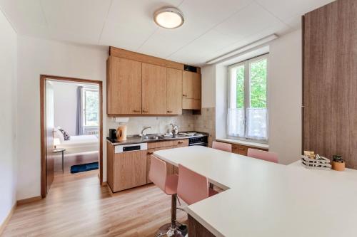 a kitchen with wooden cabinets and a white counter top at La Pergola by Quokka 360 - Cozy Stay for Mountain Adventures in Leventina in Lavorgo
