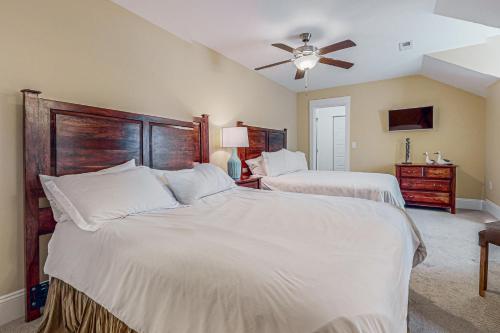 a bedroom with two beds and a ceiling fan at Hola Beaches in Corolla