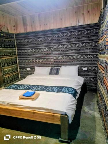 a bedroom with a bed with a wooden headboard at May Lai Homestay in Tả Van