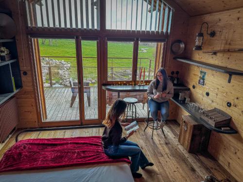a woman sitting in a room with a girl sitting on a bed at Parc Animalier de Sainte-Croix in Rhodes