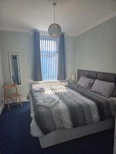 a bedroom with a large bed and a window at The Blue House in Portsmouth